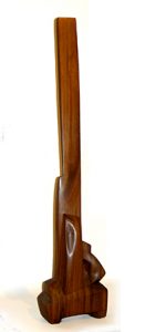 Photo of John Haley's sculpture "Citadel." Sculpture is mostly vertical, brown, abstract smooth wood.