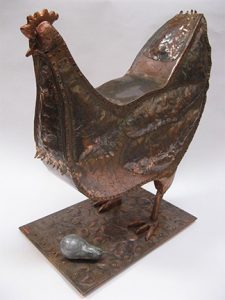 Photo of Ken Kalman's sculpture "Chicken 2." Artwork depicts a chicken and an egg.