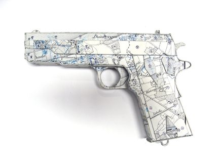 Photo of Ken Kalman's sculpture "Colt 45." Artwork depicts a gun made of maps.