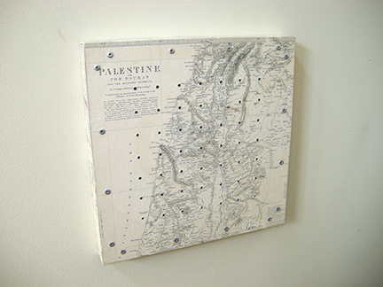 Photo of Ken kalman's sculpture "Counting the Omar." Artwork depicts a map of Palestine with holes and pegs.