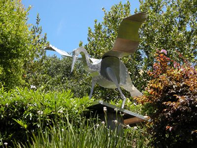 Photo of Ken Kalman's sculpture "Great Blue Heron." Artwork depicts an aluminum heron, wings outstretched.