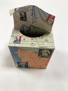Photo of Ken Kalman's sculpture "Nope". Artwork depicts a tissue box made of maps with some images of President Trump in homage to Shepard Fairey's "Hope."