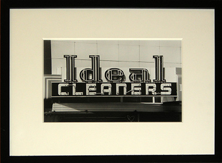 Photo of Richard Nagler's photograph "Ideal Cleaners." Artwork depicts the Ideal Cleaners neon store sign in black and white.