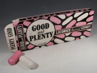 Karen Shapiro ceramic representation of Good and Plenty candy box. It has a brown background with pink and white candies.