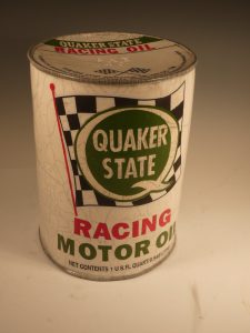 Karen Shapiro's raku-fired ceramic in the likeness of a vintage Quaker State oil canister. Shows a white label with a checkered flag, Quaker State logo, and a racing motor oil label.