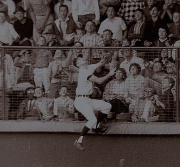 Photo of an outfielder jumping to catch a ball.