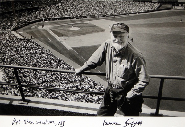 Black and white photo overlooking poet and artist Lawrence Ferlinghetti standing above the field in the stands at Shea Stadium.
