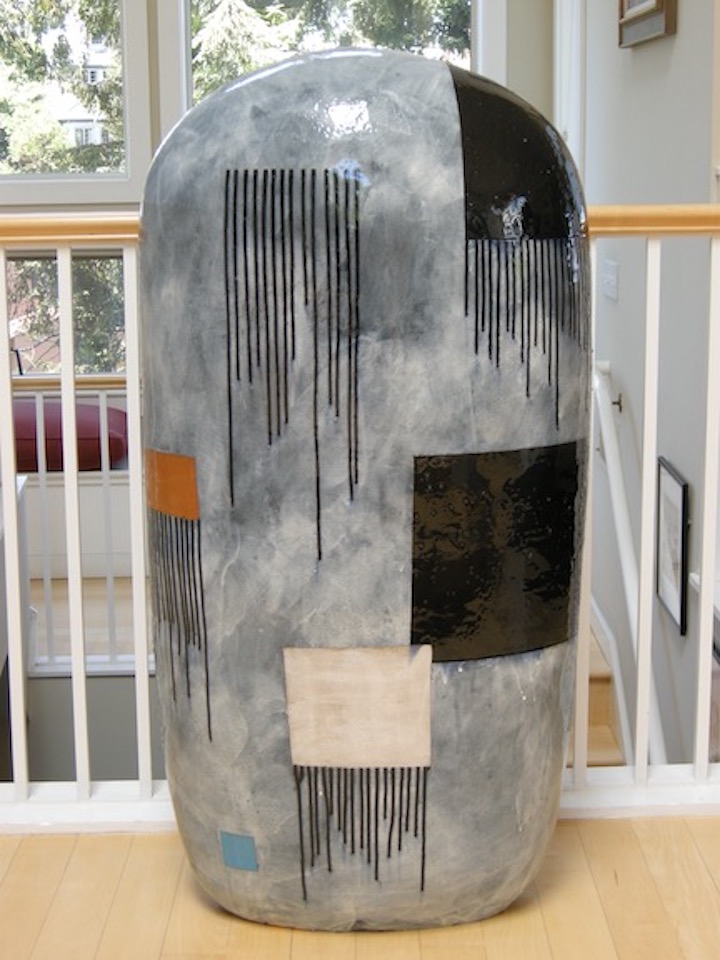 Large rectangular shaped ceramic with a rounded top, a gray background and black, white, brown, and blue squares and drip lines.