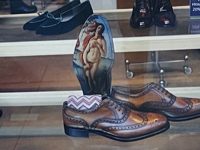 Photograph of a shoe store window with an insole with a fine art nude print on it