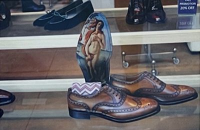 Photograph of a shoe store window with an insole with a fine art nude print on it