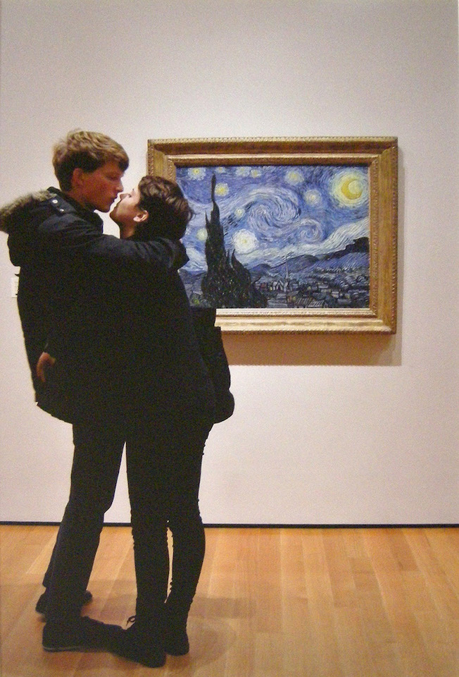 Color photograph of a couple embracing in front of Van Gogh's Starry Night painting.