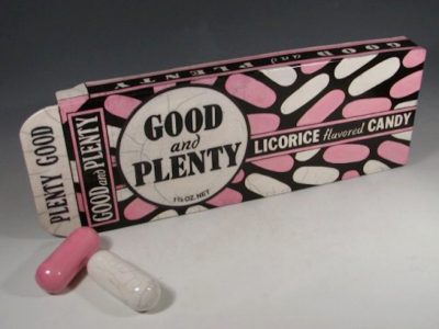 Ceramic replica of a vintage Good and Plenty candy box, black background with pink and white oval candies.
