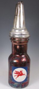 Ceramic replica of a vintage brown oil bottle with a red pegasus logo and silver funnel top