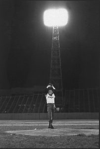 Black and white photograph of Castro pitching a baseball at a night game.