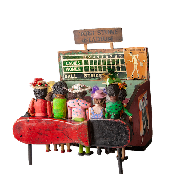 Assembled sculpture of a crowd of women watching a baseball game with a scoreboard and signage that says Toni Stone Stadium