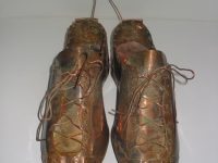 Photo of Ken Kalman's sculpture "Baseball Cleats." Artwork depicts baseball cleats made of copper.