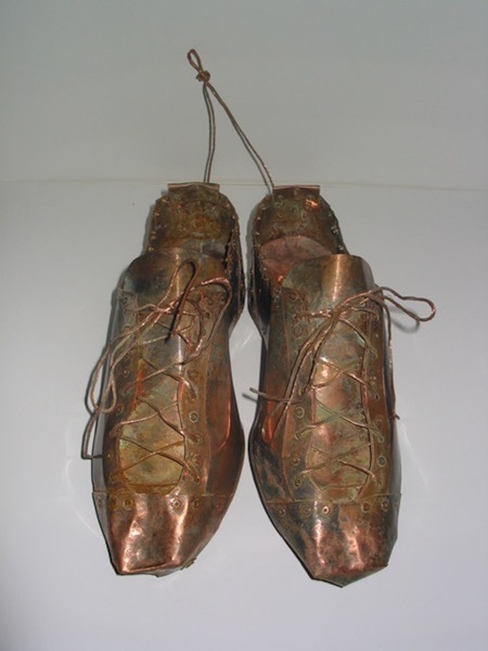 Photo of Ken Kalman's sculpture "Baseball Cleats." Artwork depicts baseball cleats made of copper.