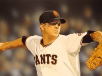 Photo of Arthur K. Miller's painting 'Mr. Perfect: Matt Cain, June 12, 2012." Artwork depicts a photorealistic Matt Cain pitching. Background is the blur of fans in the stands.