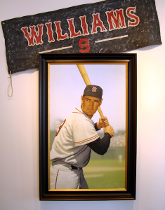 Photo of Arthur K. Miller's painting "Ted Williams at Fenway." Artwork depicts Williams at bat. A separate banner is angled above the painting.