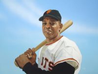 Photo of Arthur K. Miller's painting "Willie Mays, 1965." Artwork depicts a photorealistic Giant's player Willie Mays posed with bat over the shoulder. Blue background.